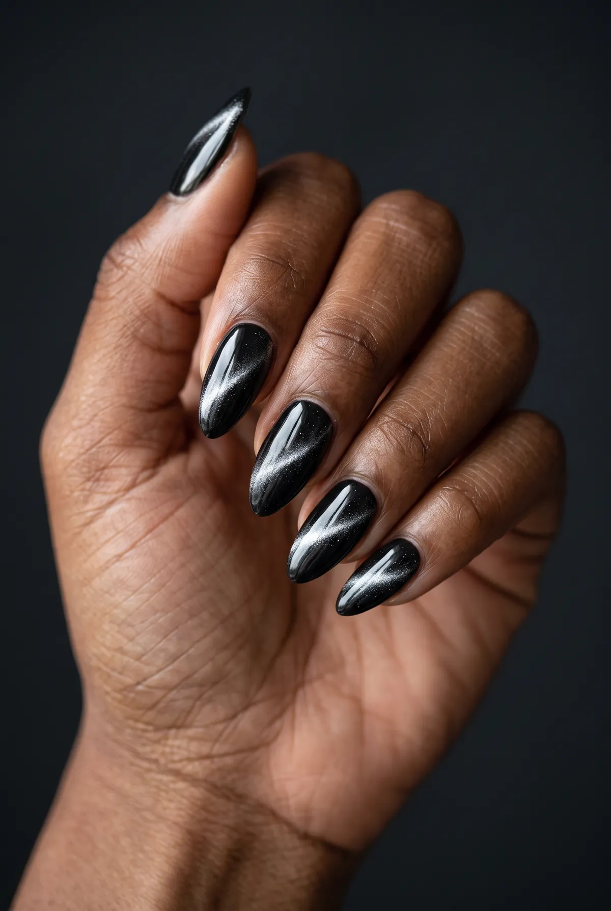 Silver Storm — almond cat eye nails with black gel base with a graphite magnetic top coat, drag the line diagonally, and finish glossy on…