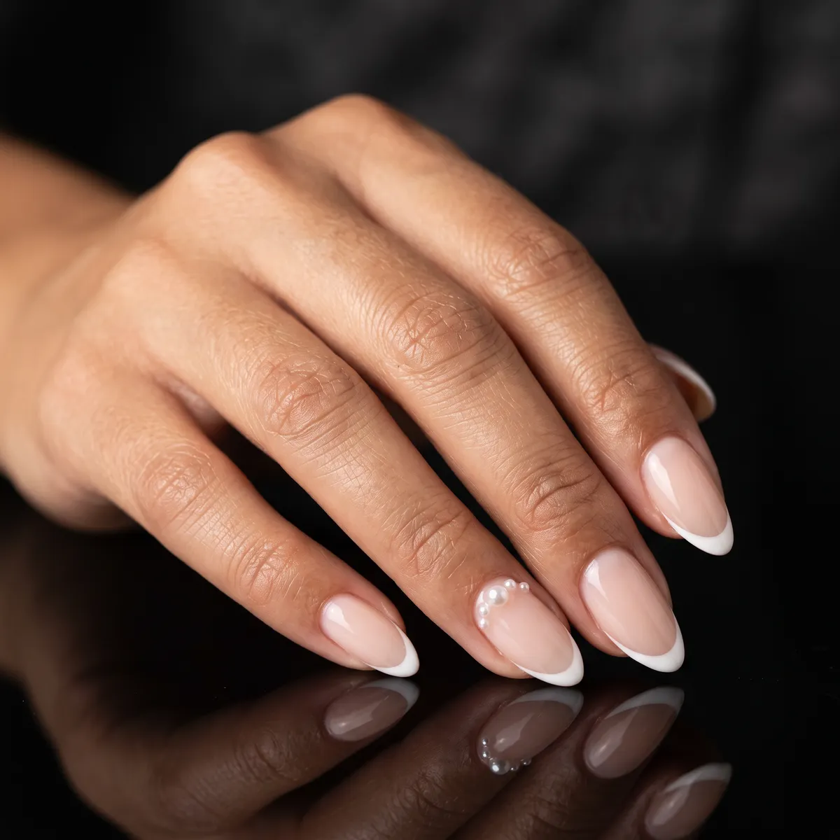 Pearl & Promise — almond french nails with micro white french with small pearl embellishments near the cuticle on the ring fingers